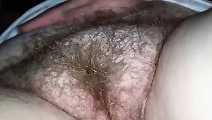 Rubbing and fingering a hairy mature vagina