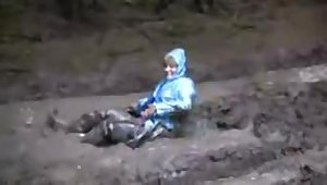 BBW cougar rolls in mud wearing a pvc raincoat